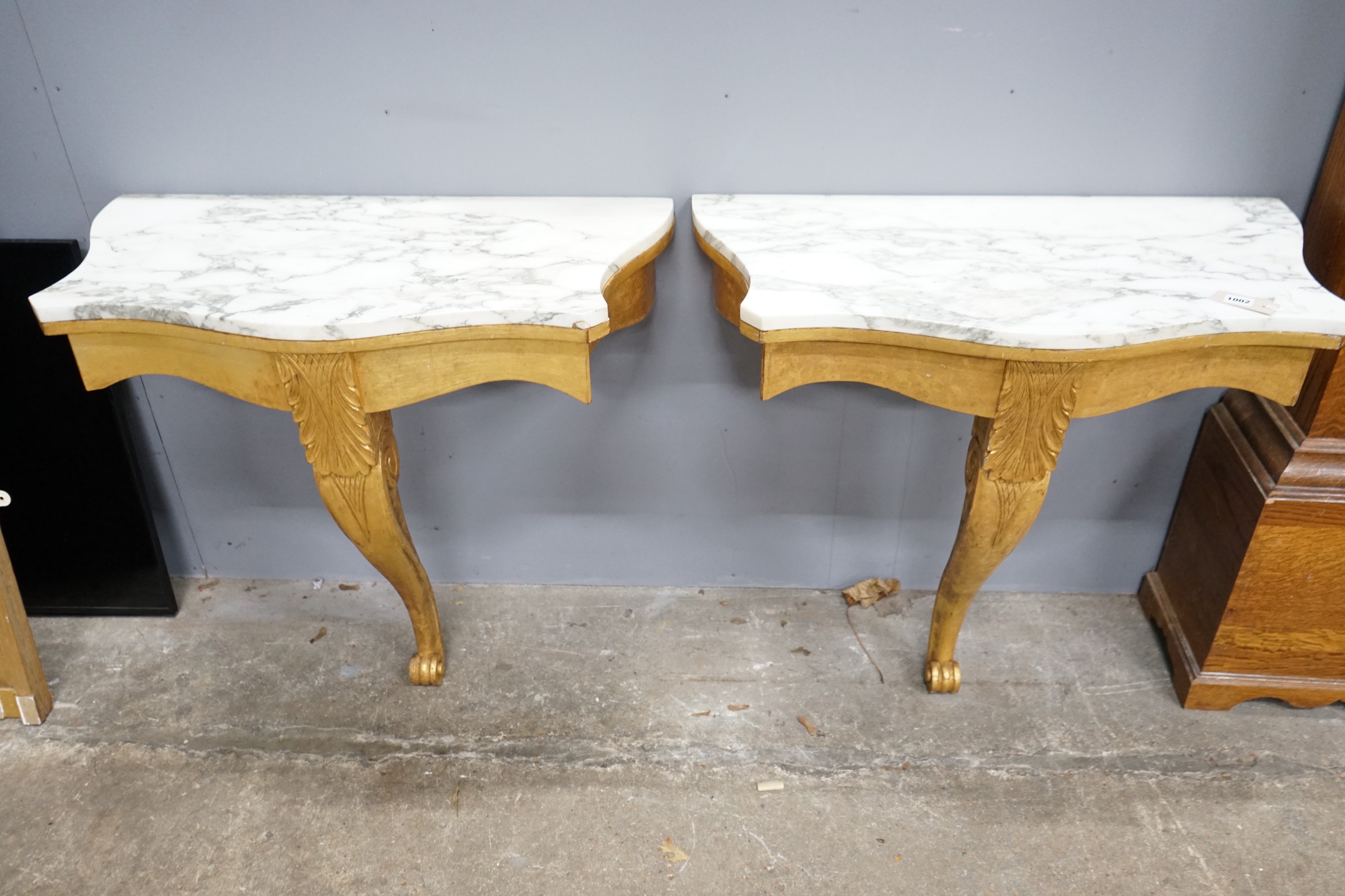 A pair of Victorian style marble topped serpentine giltwood console tables, width 84cm, depth 44cm, height 79cm